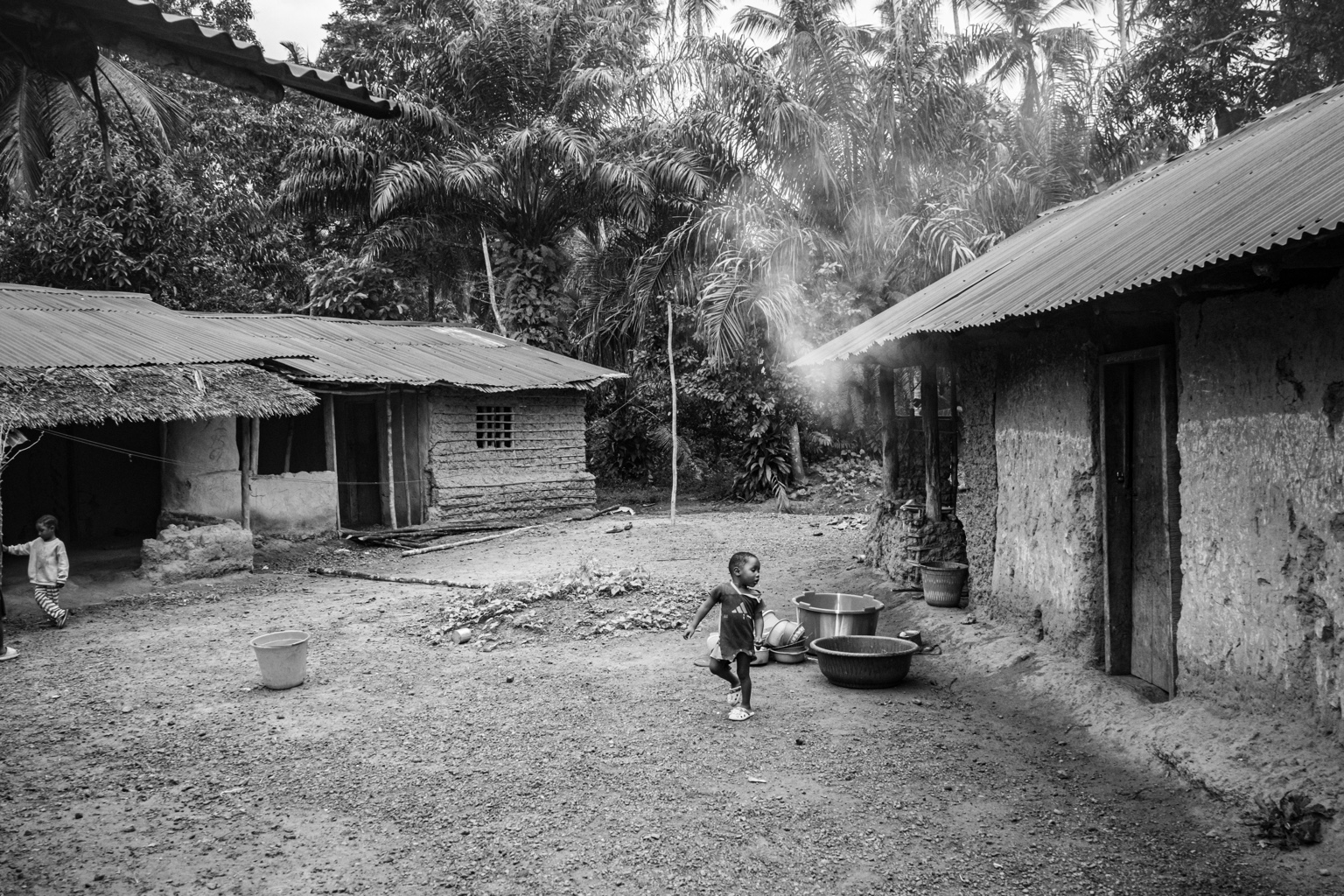 Village homes and a running child in Massatin, Liberia