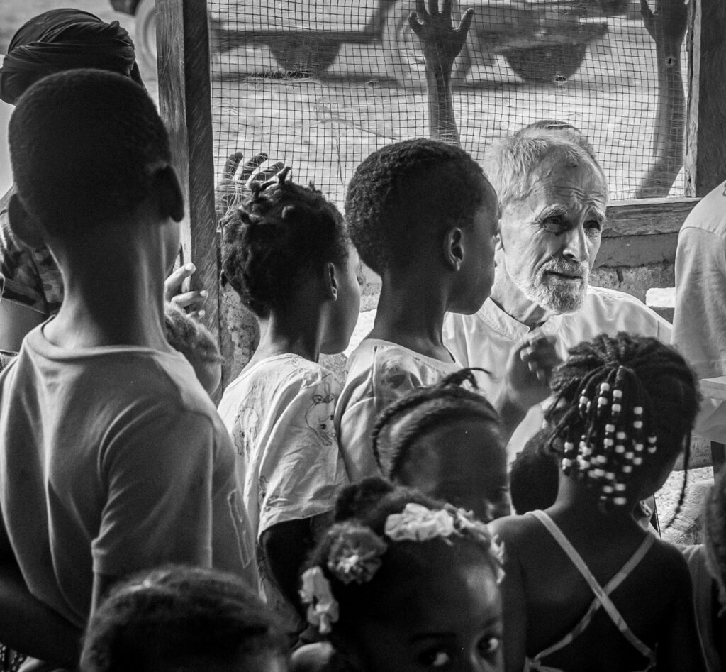 Father Gareth Jenkins surrounded by children in Massatin