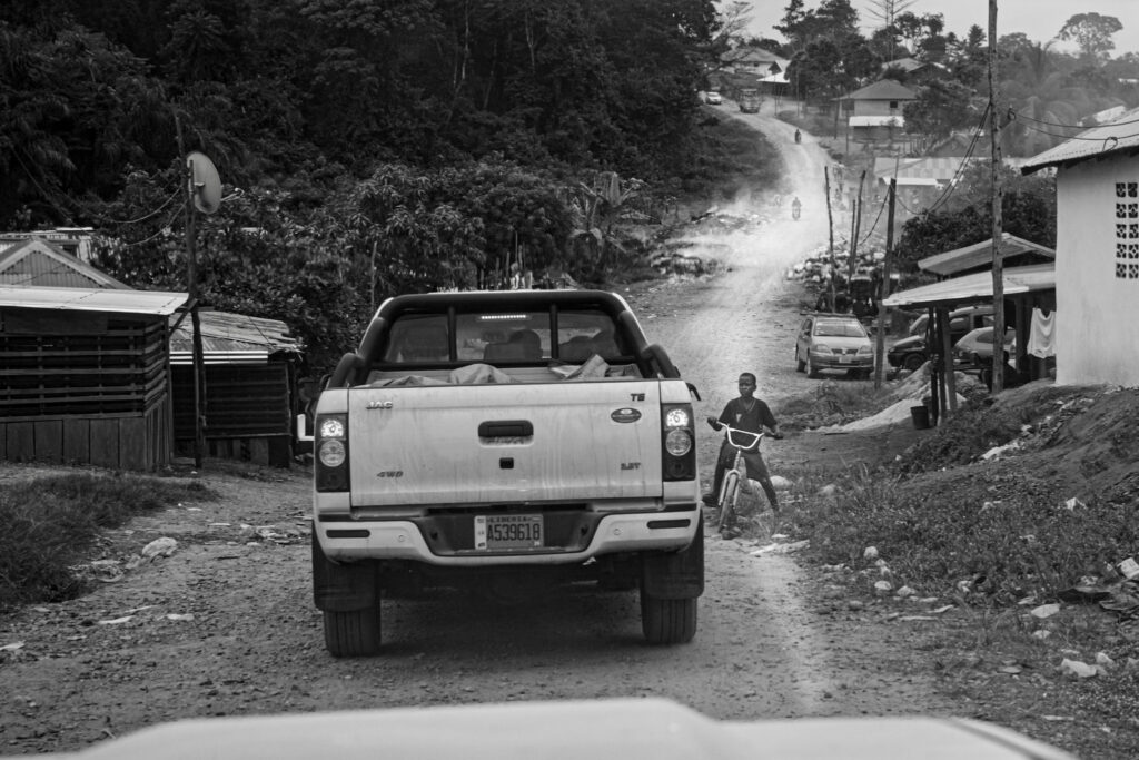 A pickup truck on a dirt road through Grand Cape Mount County, Liberia