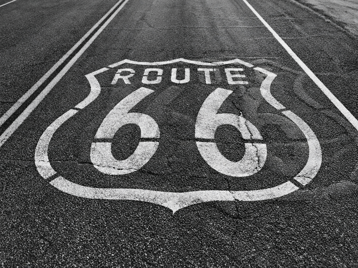 A weathered Route 66 shield painted on the road turns an everyday stretch of asphalt into one of the most recognisable symbols of American travel.