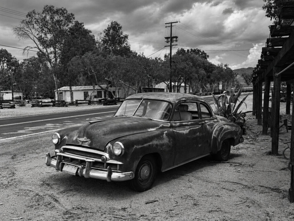 A stationary, weathered car carries traces of age and use, offering a less polished view of American motoring culture.