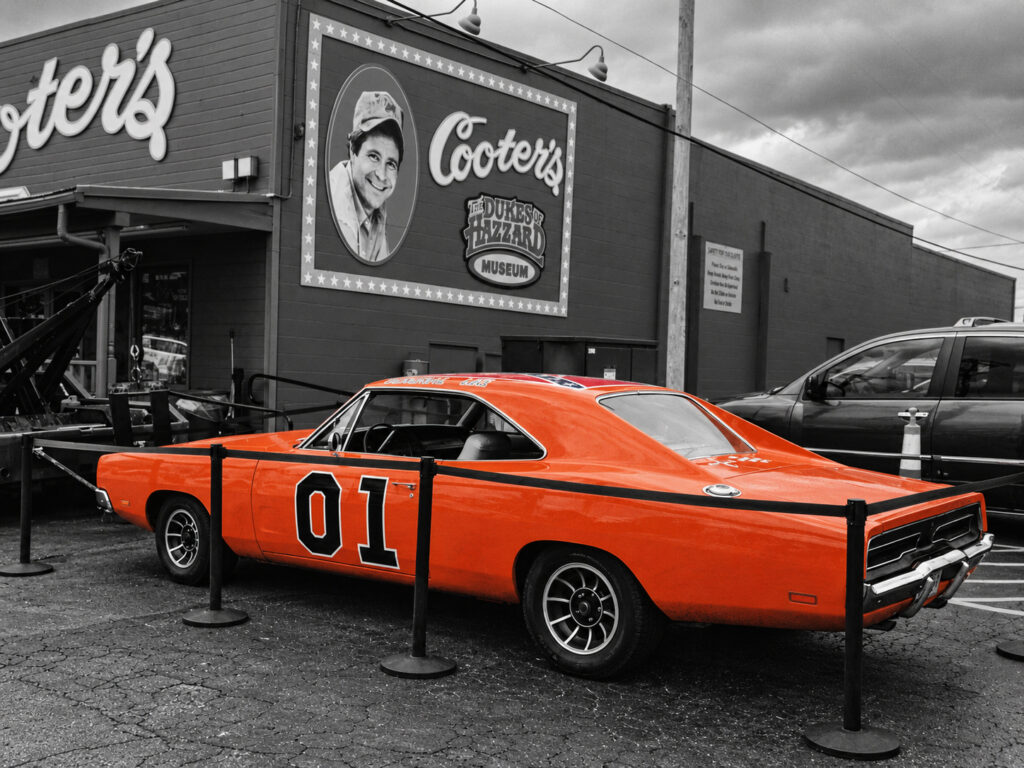 An orange car associated with the television series The Dukes of Hazzard appears outside Cooter’s museum in Tennessee, connecting a real roadside setting with a familiar screen image.