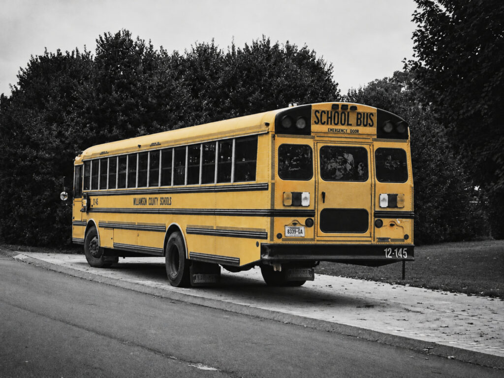 A yellow American school bus, familiar from films and television, is photographed as a working everyday vehicle.