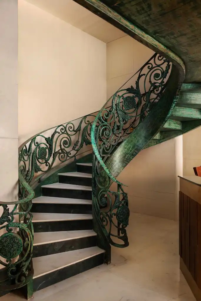 The curved green wrought-iron staircase at Abode Jaipur