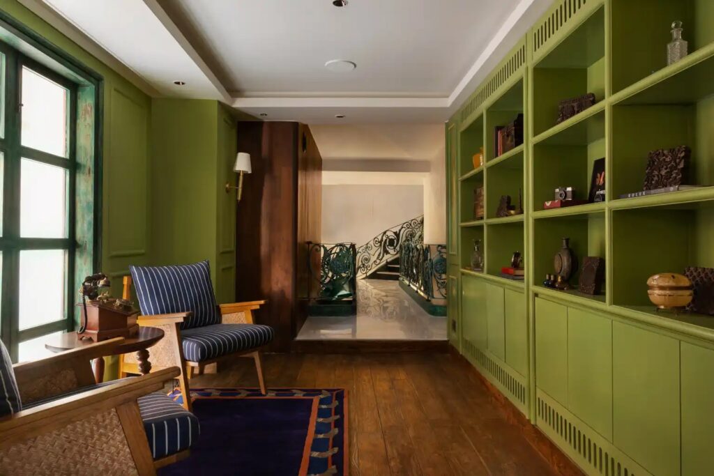 Book lounge with deep green shelving at Abode Jaipur