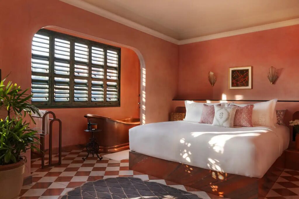 Pink guest room with timber shutters at Abode Jaipur