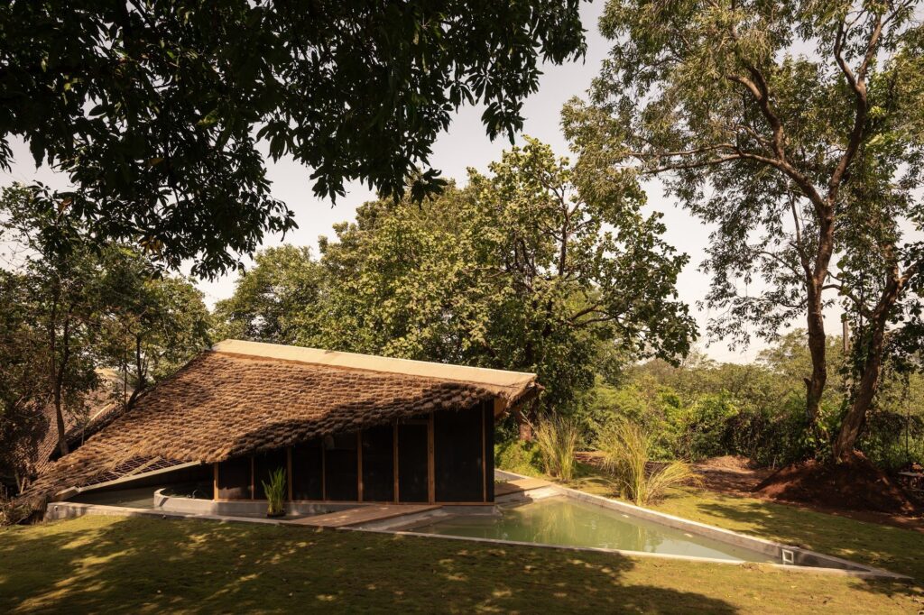 The thatched roof of Bridge House among the trees