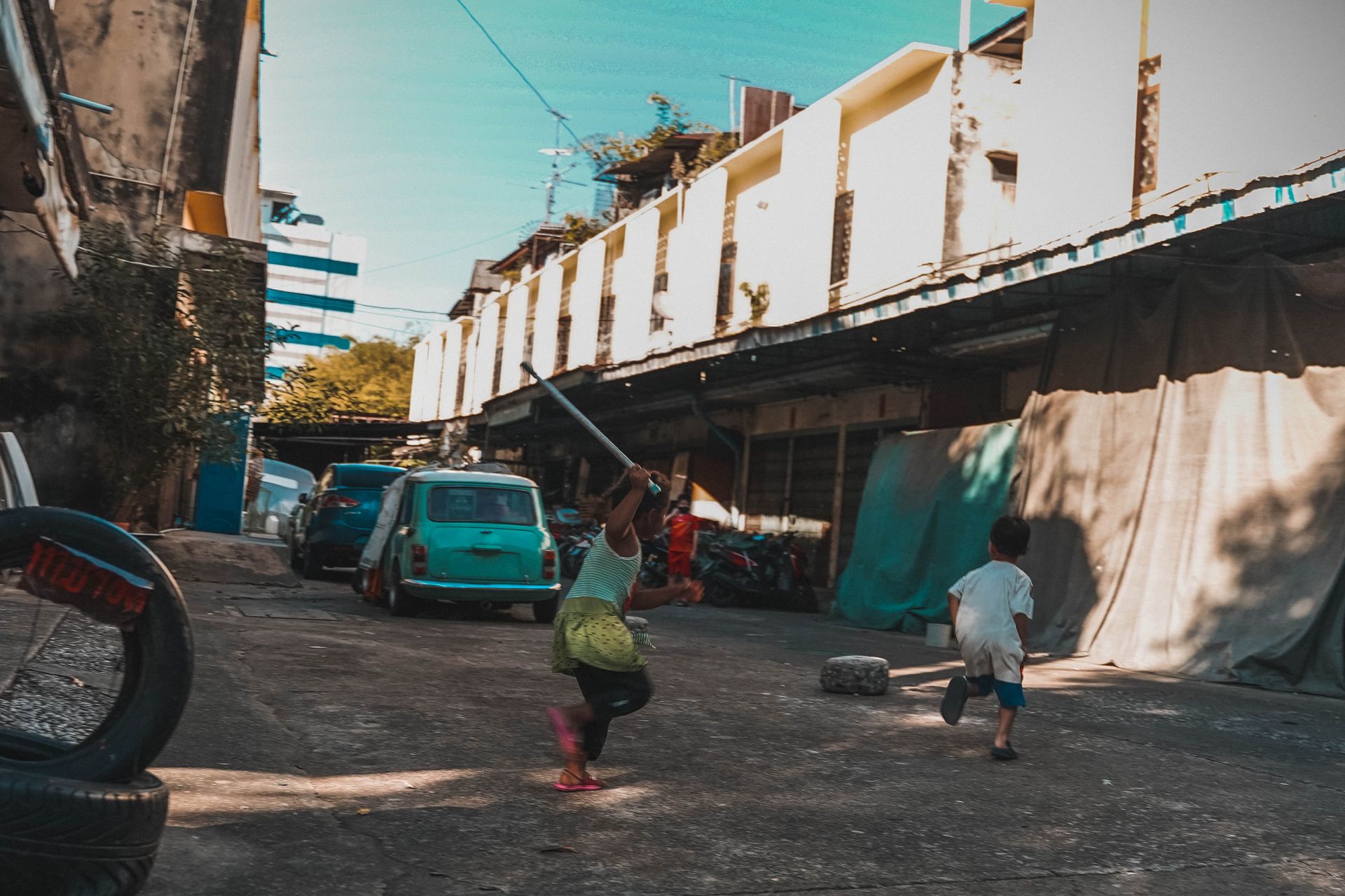 Children playing and running in a narrow city street, illustrating environmental psychology and child development