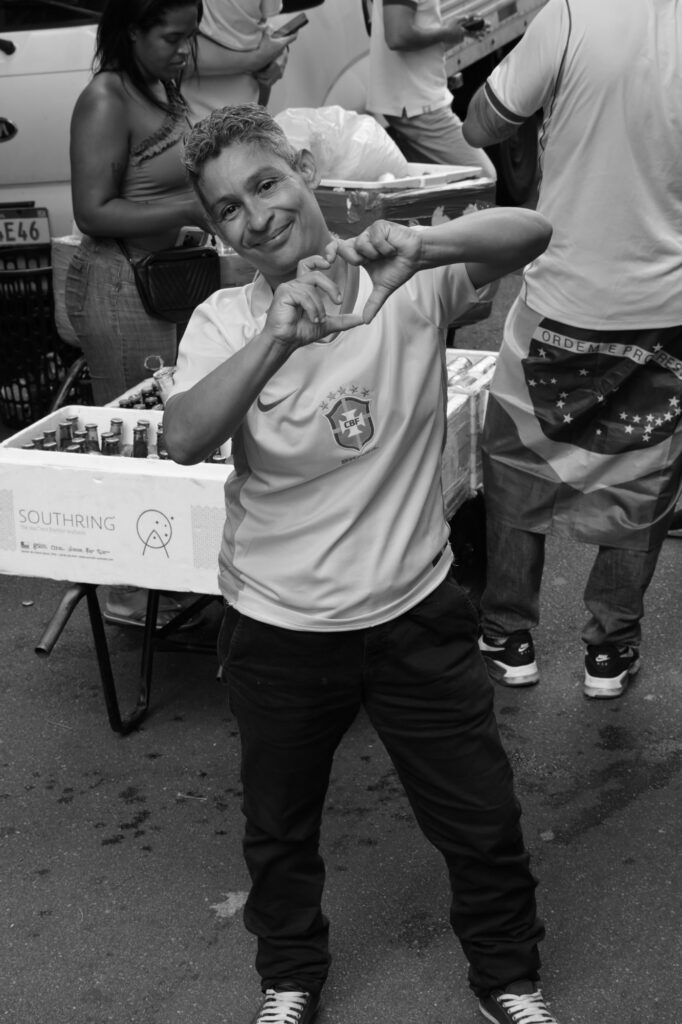 A person moves among people gathered for the demonstration. The photograph isolates an individual action within a larger event rather than presenting the crowd as a single undifferentiated subject.