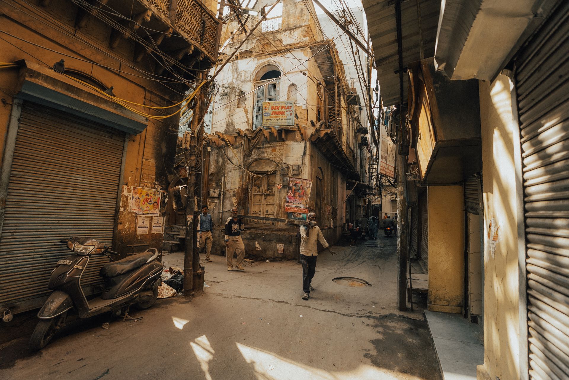 A narrow old-city street with deep shade and a strip of sunlight, showing how urban form shapes heat