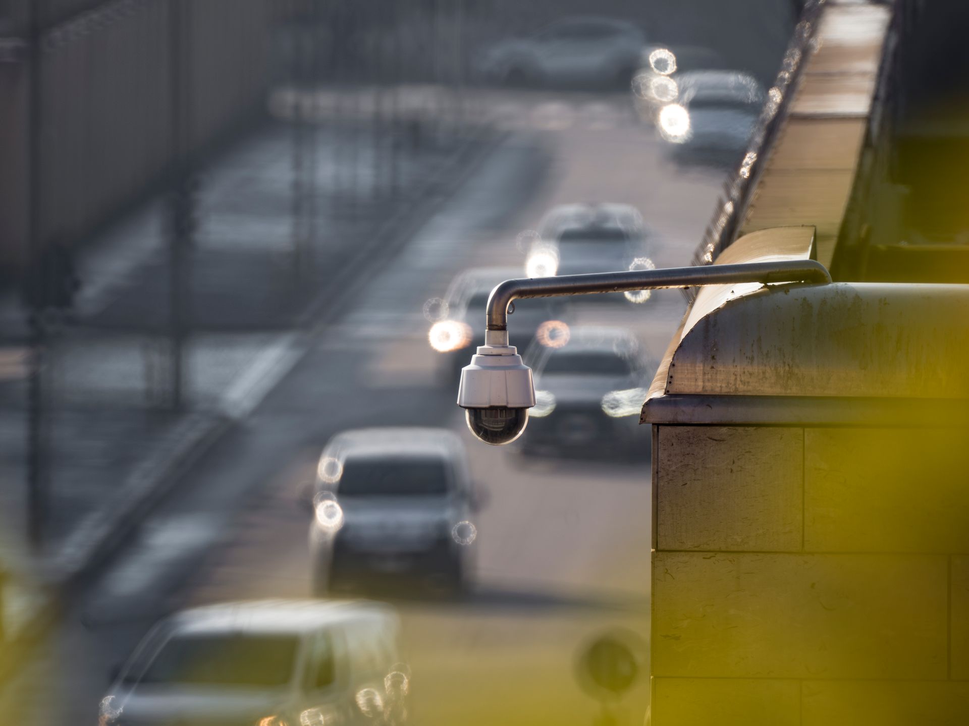 A dome security camera monitoring traffic on a busy city street
